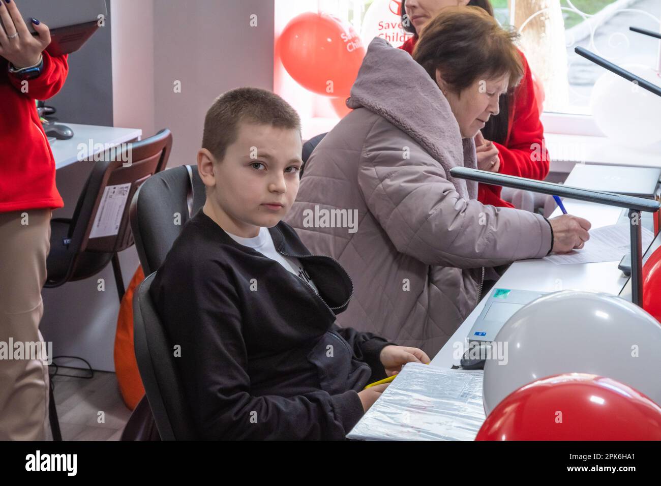 I bambini siedono a un tavolo con computer portatili e tablet in classe. Apertura ufficiale del Centro di apprendimento digitale nella Scuola superiore professionale di tecnologie informatiche e costruzione di Lviv, fondata dall'organizzazione umanitaria internazionale Save the Children con il sostegno del Ministero degli Affari Esteri norvegese. L'obiettivo del Digital Learning Center è un accesso sicuro all'apprendimento a distanza per i bambini dai 6 ai 17 anni, accesso all'istruzione interattiva non formale. Il centro di apprendimento digitale garantisce ai bambini un accesso continuo all'istruzione e alla socializzazione interna di Foto Stock