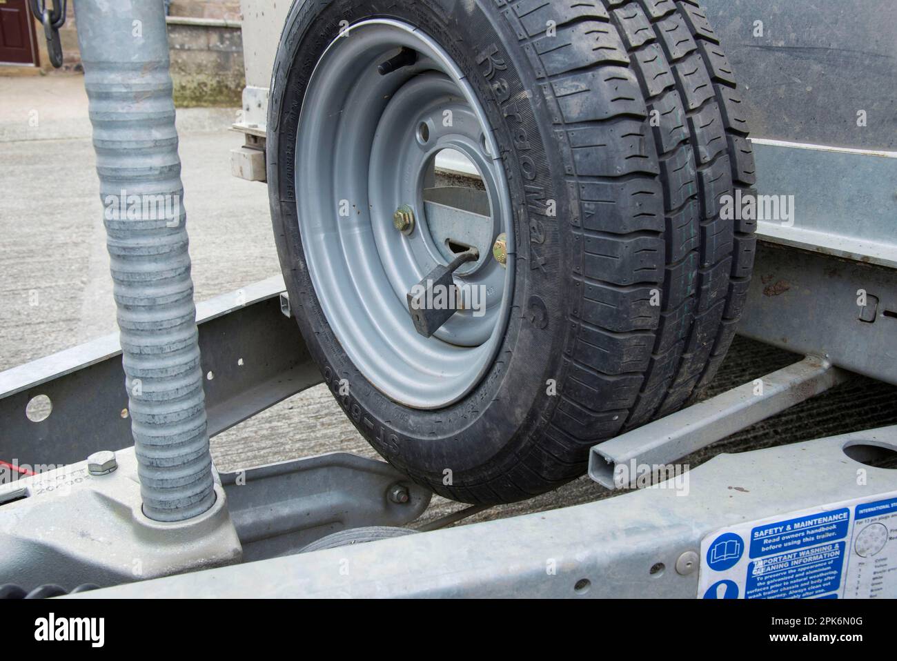Blocco della ruota di scorta sul rimorchio agricolo nel cortile, Lancashire, Inghilterra, Regno Unito Foto Stock