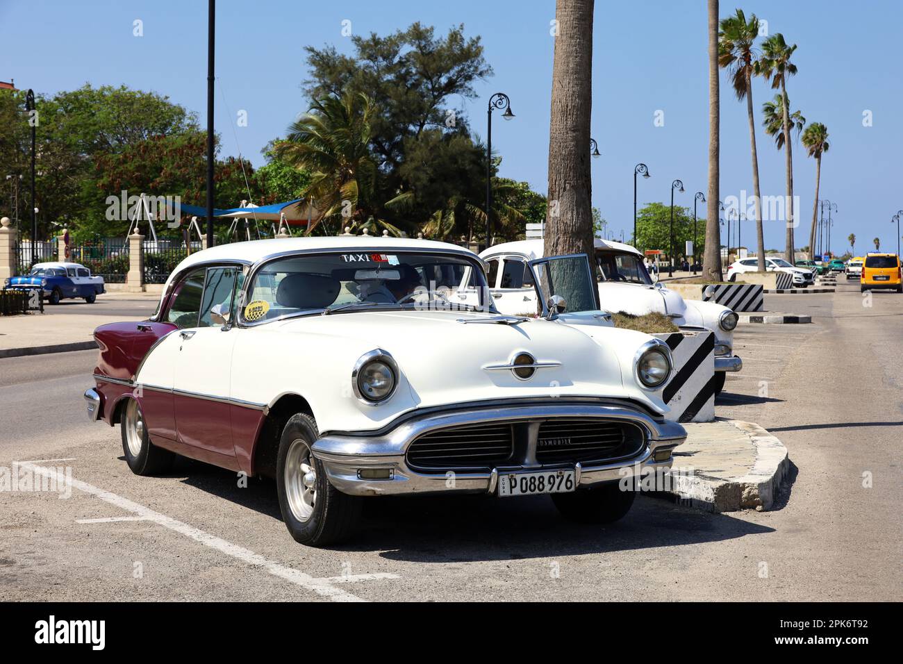 Tassista in attesa di turisti in auto d'epoca classica sulla strada cittadina a l'Avana Foto Stock