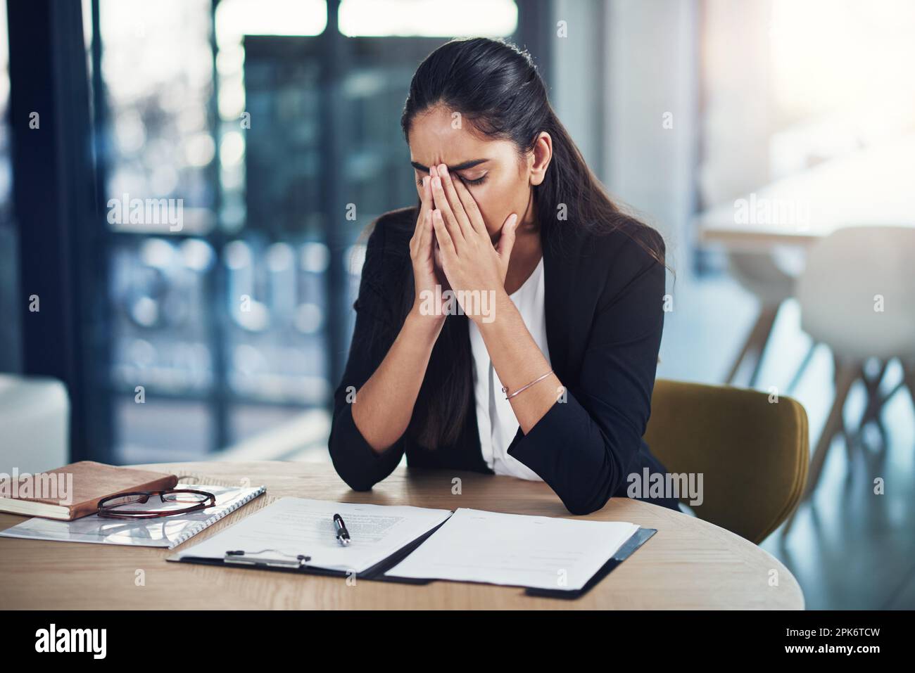 È stata una giornata particolarmente frustrante. una giovane donna d'affari che guarda stressato in un ufficio. Foto Stock