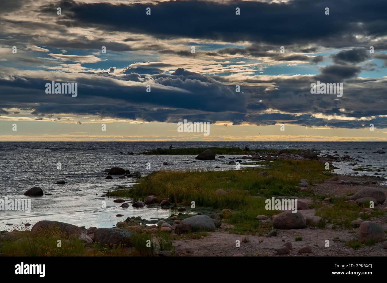 Sputata rocciosa che si estende fino al mare sotto un cielo spettacolare Foto Stock