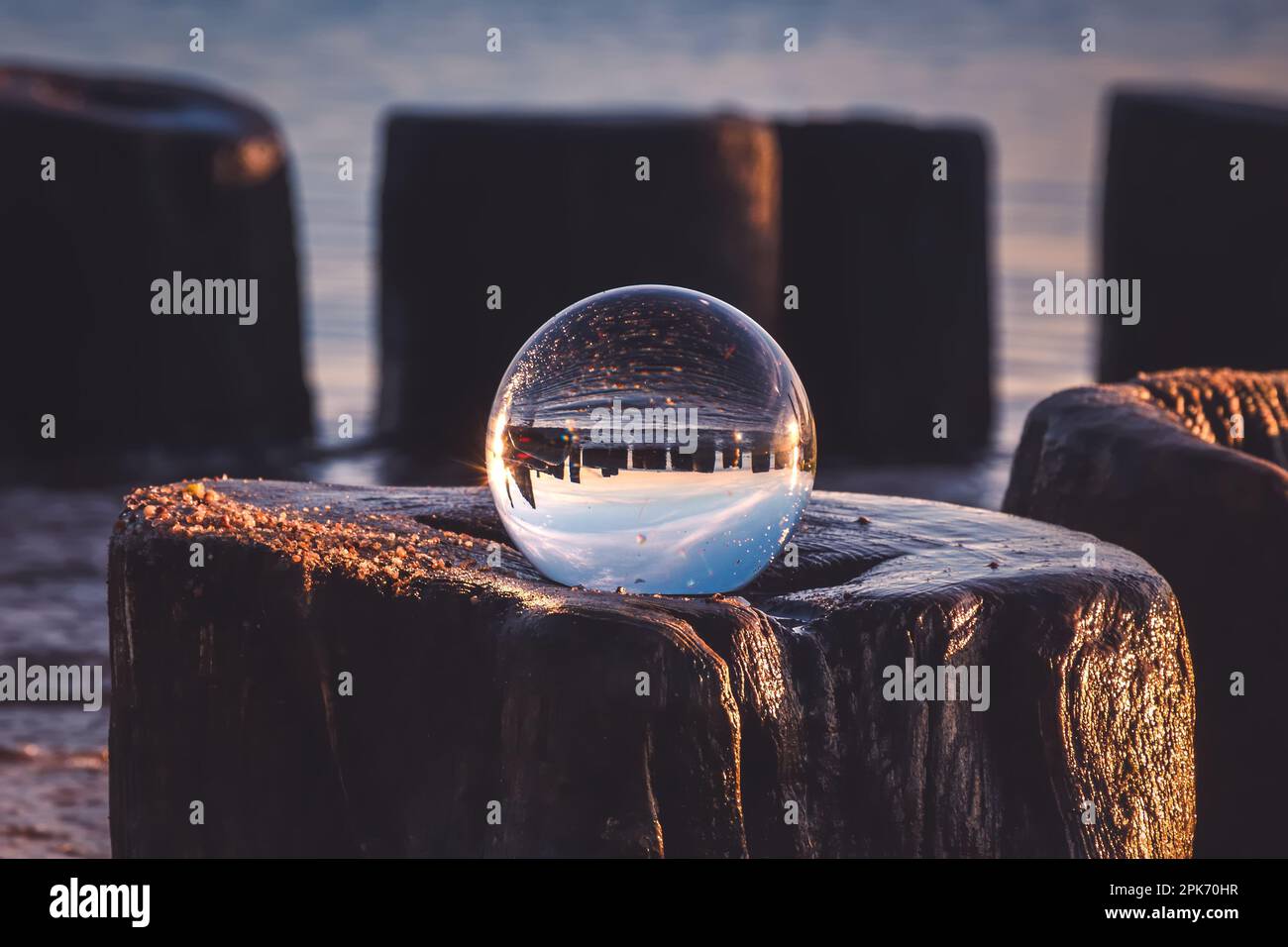 Idea astratta con acqua con un effetto interessante. Palla di vetro su sfondo sfocato su una spiaggia di mare a Gdynia, Polonia. Foto con un dep. Poco profondo Foto Stock