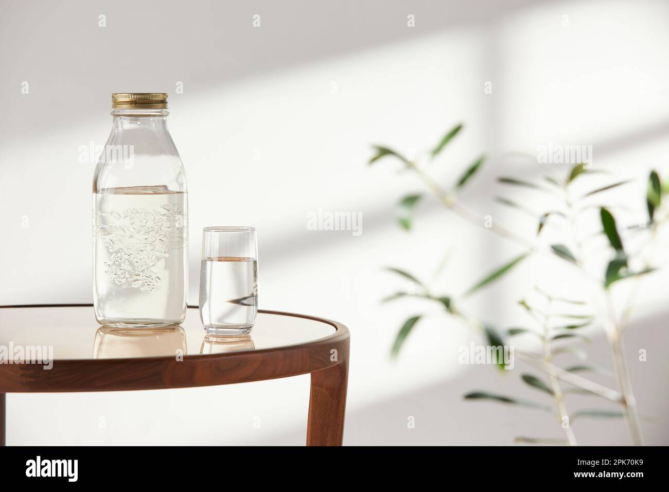 Questa camera offre un'atmosfera tranquilla con luce naturale. Ci sono vasi di argilla, bottiglie di vetro, caffè e vari oggetti sul tavolo. Foto Stock