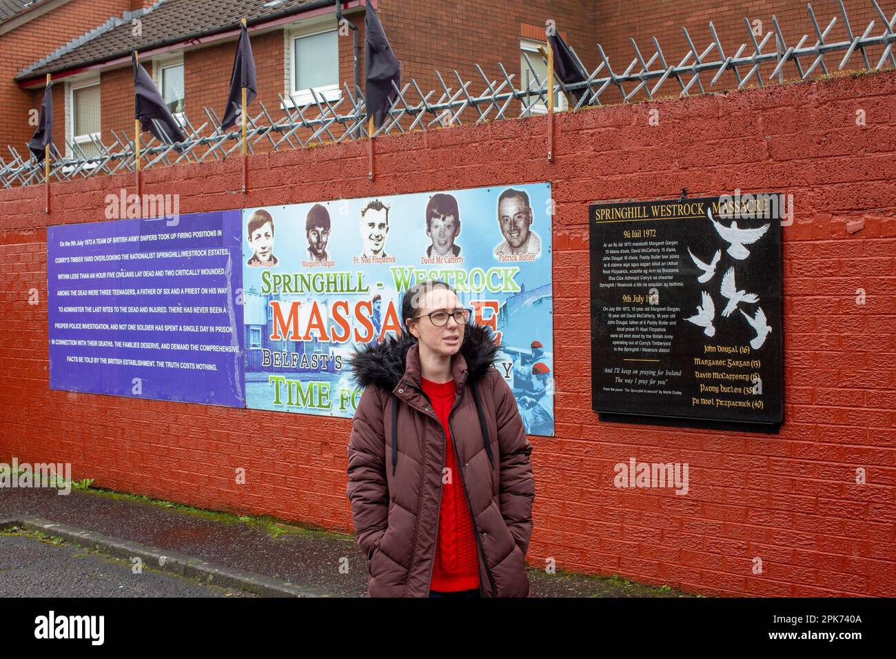 Natasha Butler nipote di Paddy Butler che è stato ucciso durante le uccisioni di Springhill Westrock di fronte al murale commemorazione. Foto Stock