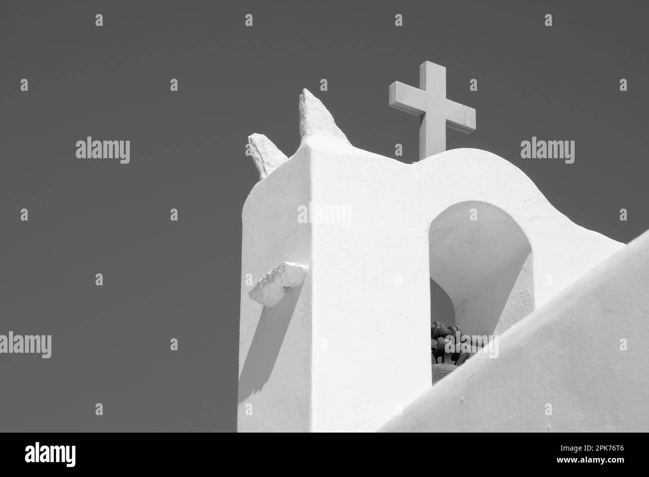 Una croce sulla cima di una chiesa ortodossa imbiancata in Grecia e un cielo blu sullo sfondo in Grecia iOS in bianco e nero Foto Stock
