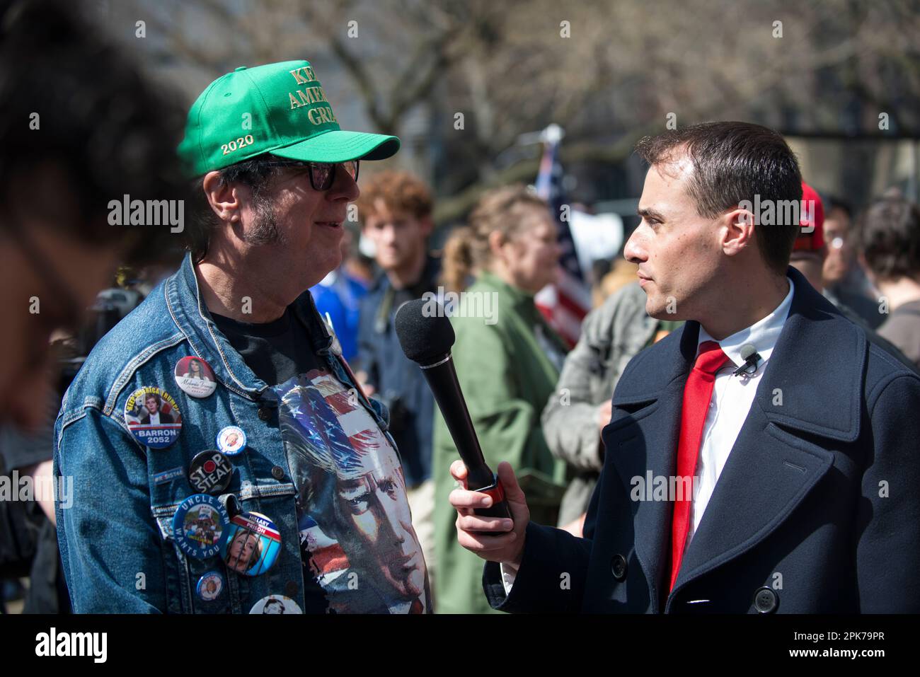 Reporter intervista l'uomo che indossa i tasti del presidente Trump, al di fuori di Manhattan Criminal Court House, New York, il 04 aprile 2023. Foto Stock