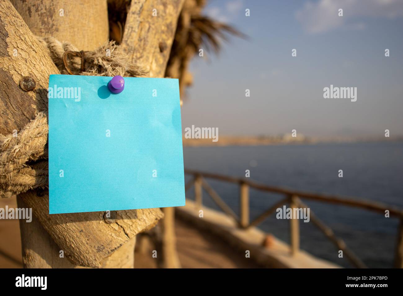 corda con palo di legno e una nota di carta quadrata blu con spazio libero vuoto per il modello o l'area di copia vuota Foto Stock