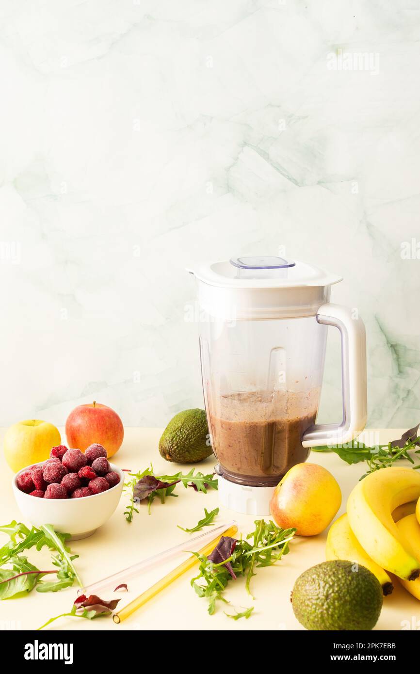 Colazioni salutari, frullati salutari e deliziosi con ciliegie e banane surgelate e avocado, proteine della piselli e verdure miste, frullato bicchiere mixer Foto Stock