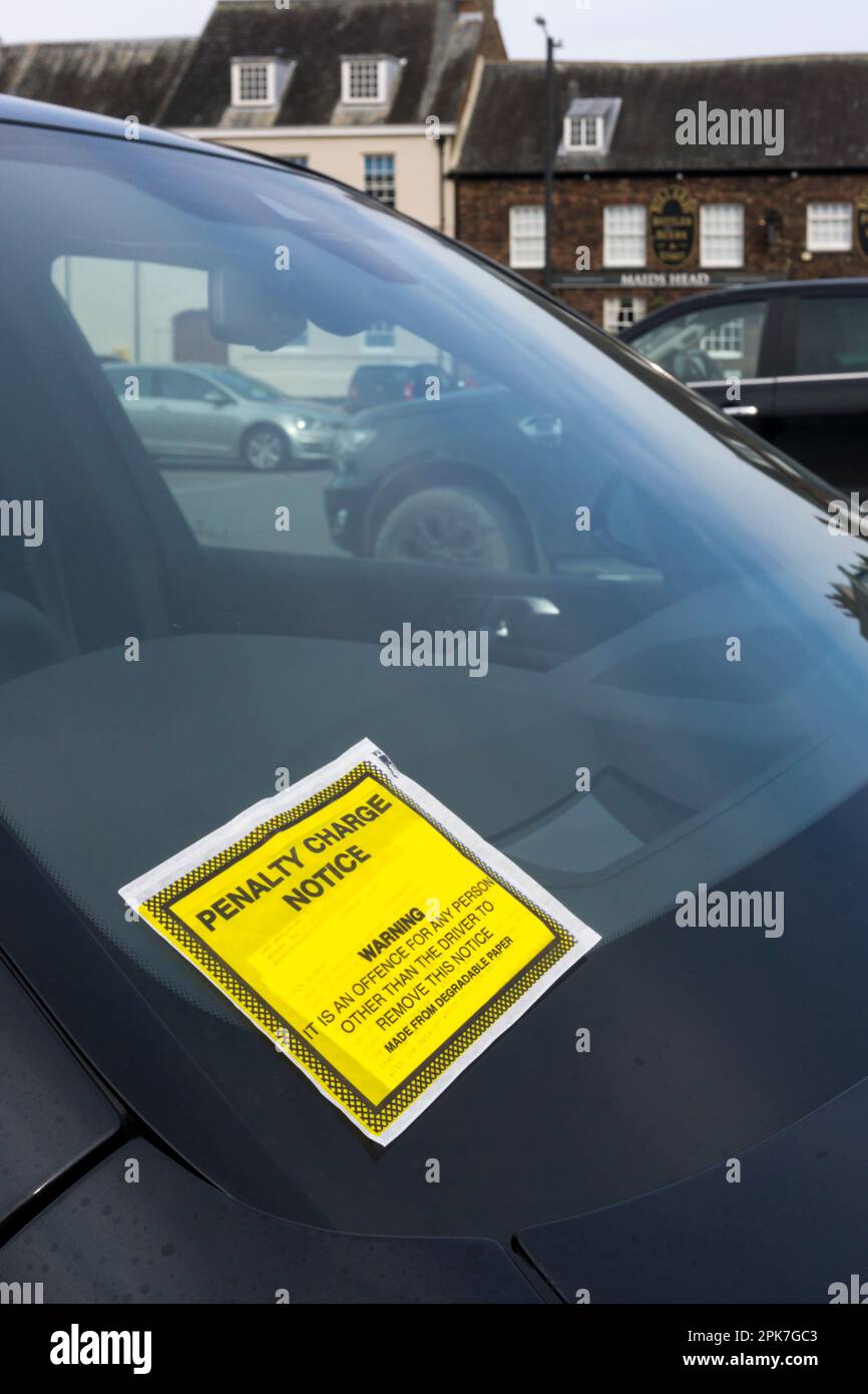 Avviso di penalità fissato al parabrezza di un'auto parcheggiata in un parcheggio. Foto Stock