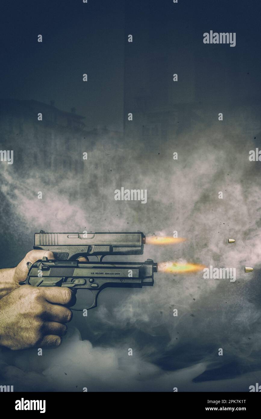 mani che tengono pistole sparare con fumo e sfondo di case Foto Stock