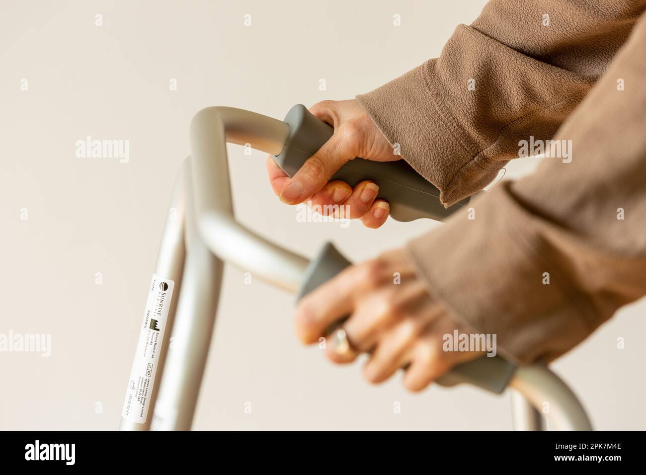 Primo piano delle mani su un telaio zimmer Foto Stock