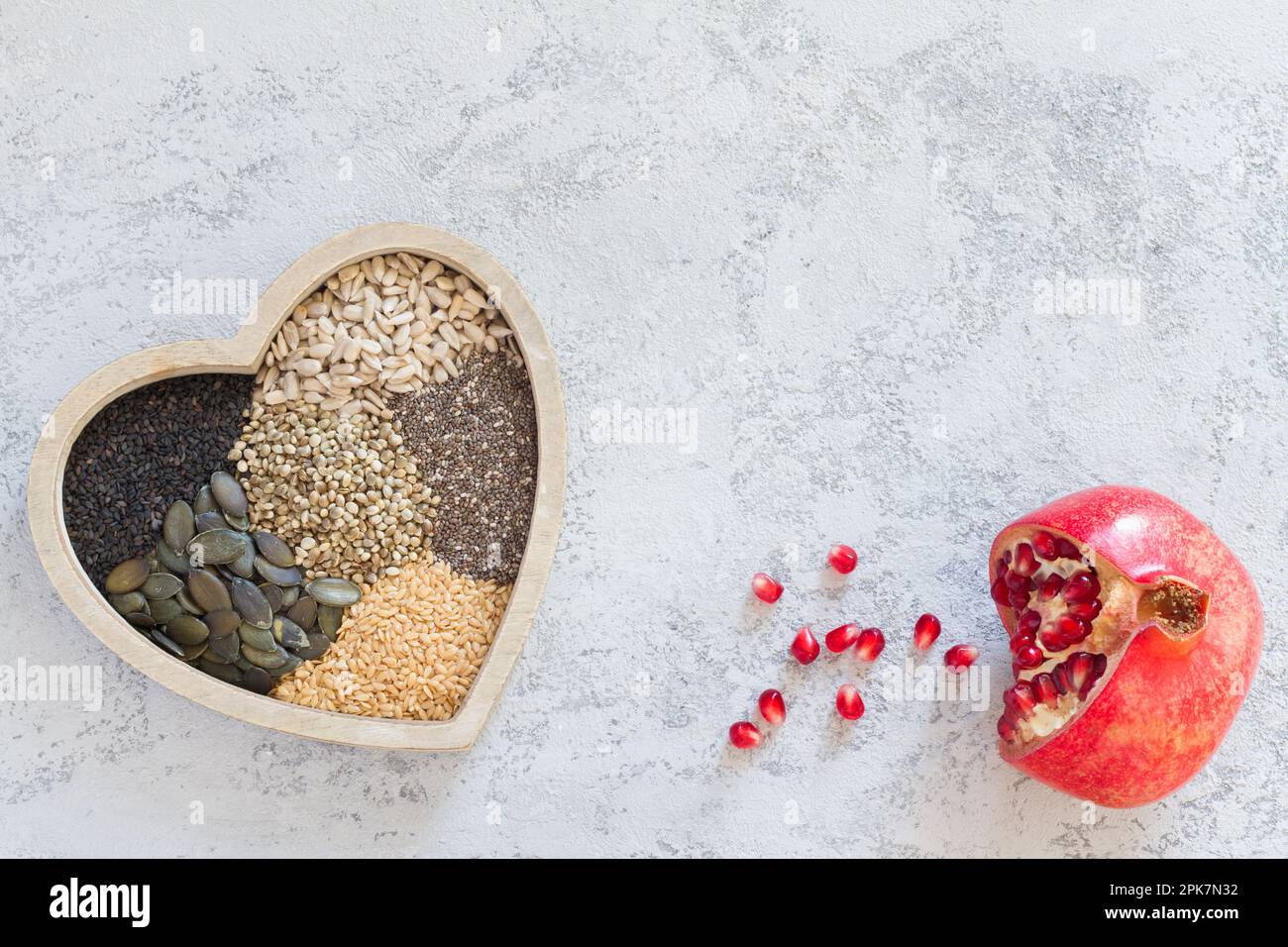 Frutti di melograno e vari semi sani nel cuore, dieta sana concetto Foto Stock