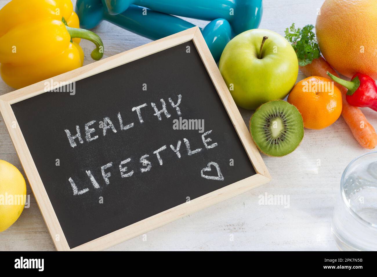 Parole "stile di vita sano" sulla lavagna. Frutta, verdura e manubri, dieta sana e concetto di sport Foto Stock