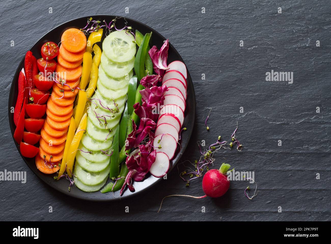 Verdure fresche a fette in colori arcobaleno su sfondo nero, sana dieta concetto Foto Stock