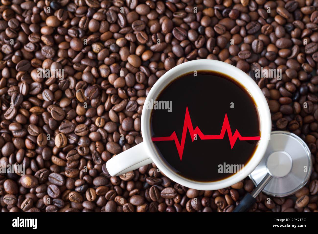 Linea heartbeat rossa, cardiogramma nella tazza di caffè sullo sfondo dei chicchi di caffè, effetto concettuale della caffeina sul cuore Foto Stock