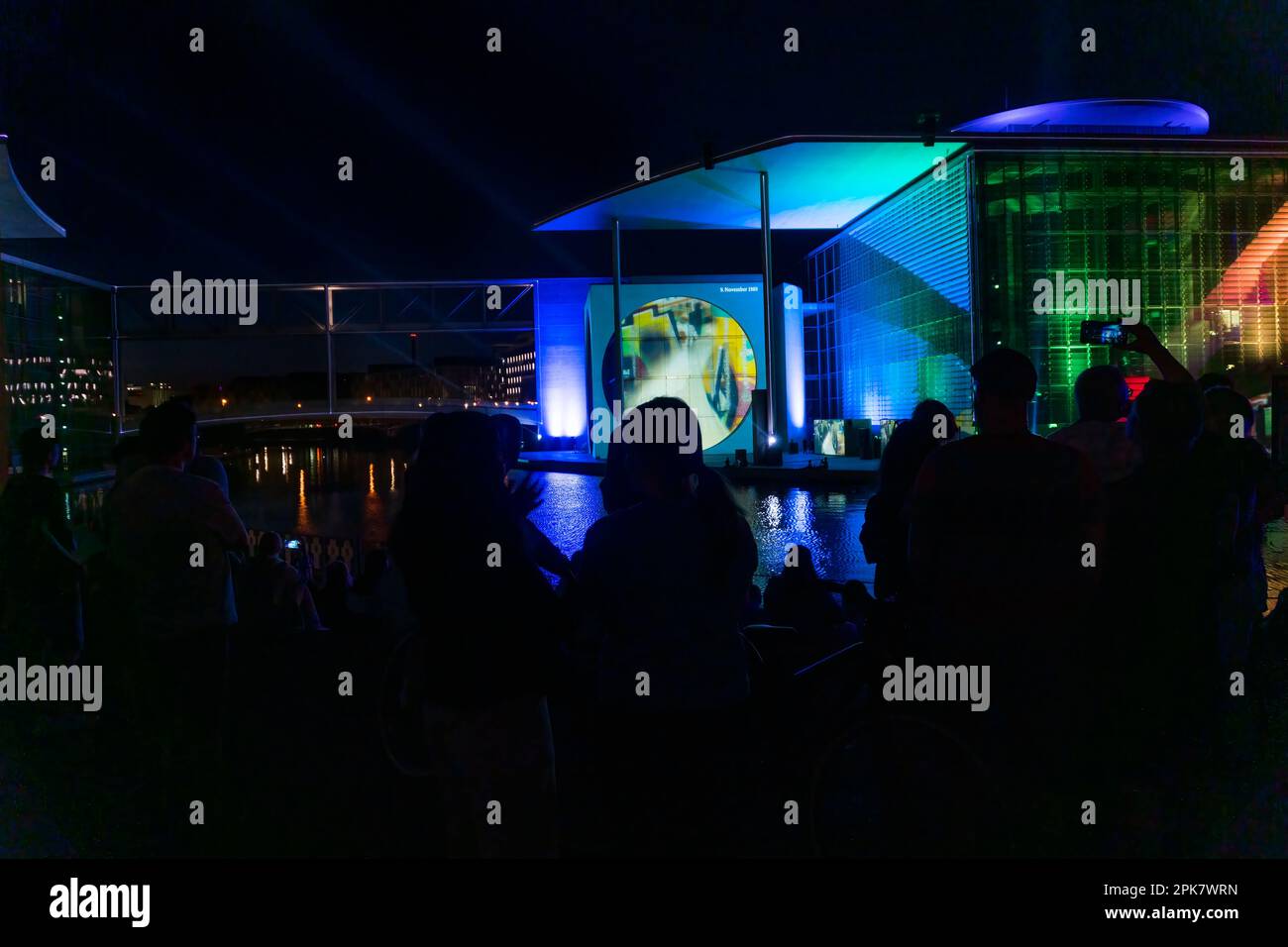 Berlino, Germania-8 agosto 2022: Le persone ammirano un evento commemorativo fatto di luci e film proiettati sull'edificio del governo sul fiume Sprea a Nigh Foto Stock