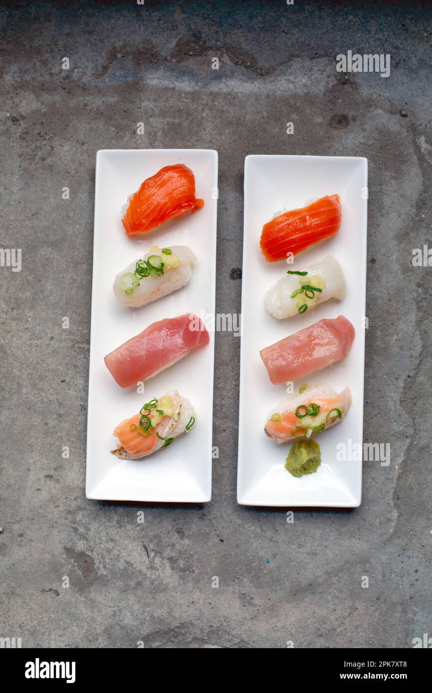 Un piatto di sushi con pesce fresco e riso sistemato con cura sul piatto con le guarnite. Foto Stock