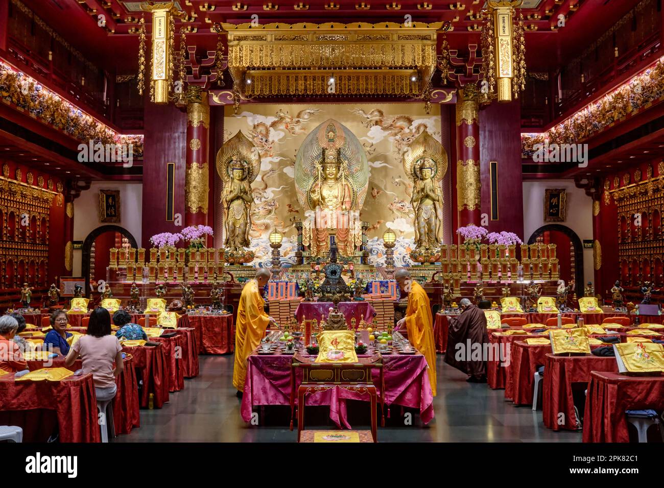 I monaci buddisti stanno eseguendo preghiere presso il santuario principale nel Tempio e Museo del dente di Buddha, Chinatown, Singapore Foto Stock