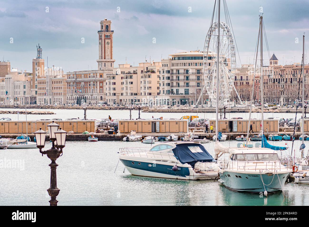 Panorama di Bari, Puglia o Puglia, Italia meridionale con mare Mediterraneo, barche, lampioni, ruota panoramica e architettura fascista sul lungomare Foto Stock