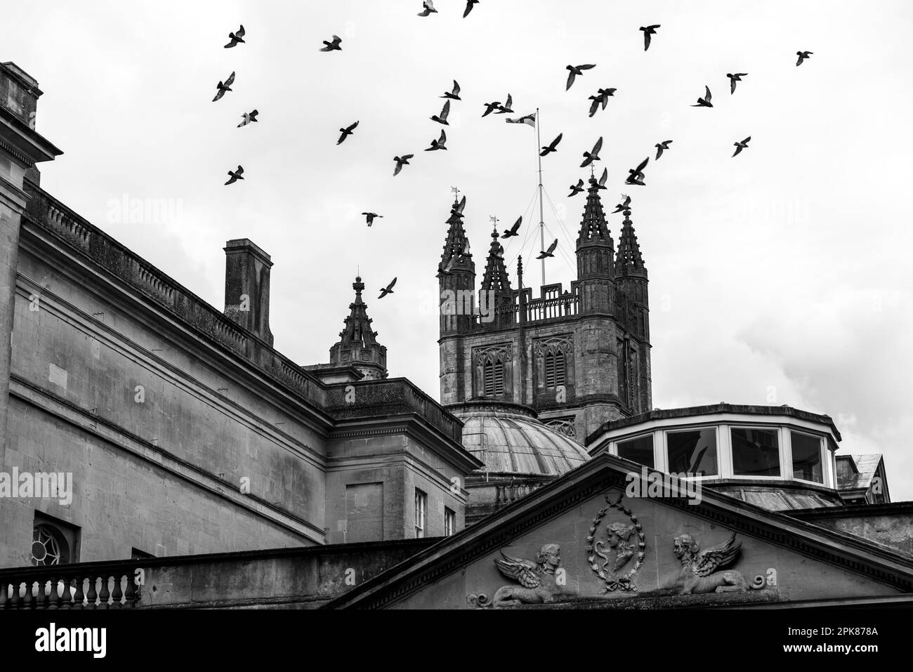 Immagine in bianco e nero degli uccelli che volano sopra l'abbazia di Bath nel Regno Unito Foto Stock