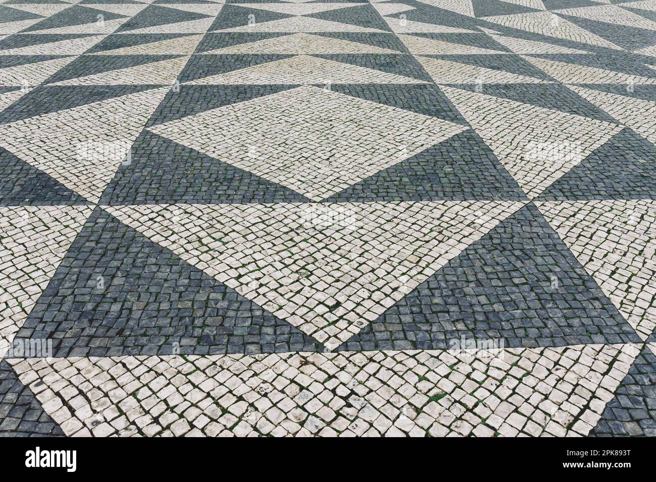 Pavimento in mattonelle a Lisbona, Portogallo. Mosaico tradizionale di vecchio tipo sul marciapiede o sul marciapiede della città Foto Stock