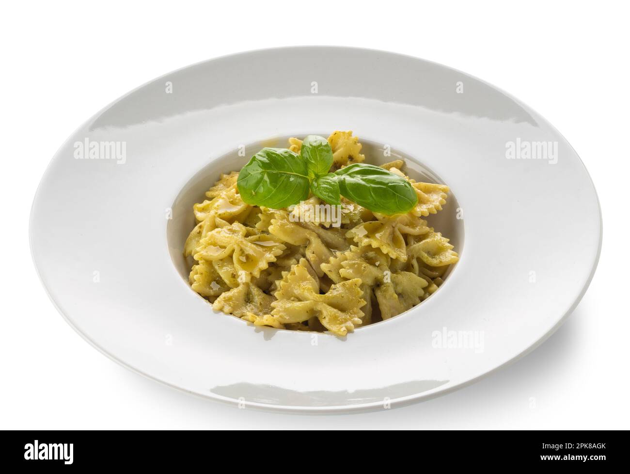 FARFALLE pasta con pesto, tipica salsa genovese di basilico, pinoli, olio d'oliva e parmigiano in un piatto bianco con prugne Foto Stock