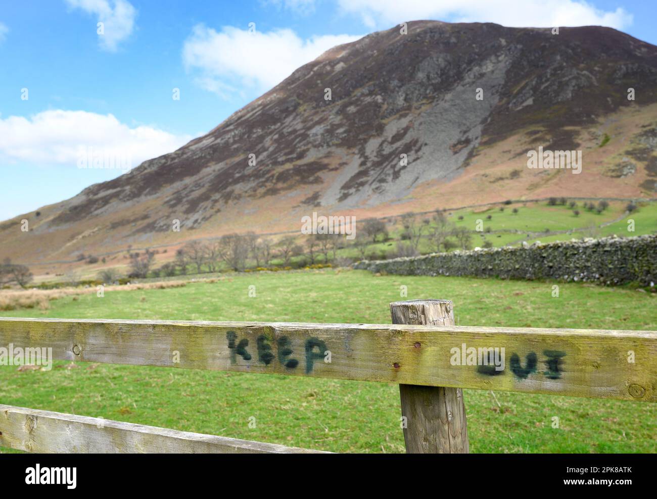 Lake District, Cumbria, Regno Unito. TENERE fuori scritto su un cancello con una vista di Whiteside Fell (719m / 2359ft) all'estremità nord Crummock acqua Foto Stock