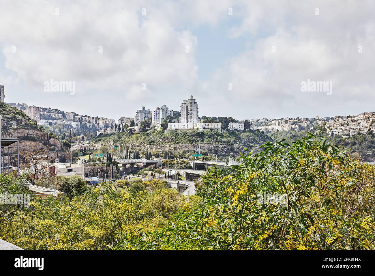 Incrocio stradale nella città di Haifa e gli edifici della città nel verde in primavera. Foto Stock