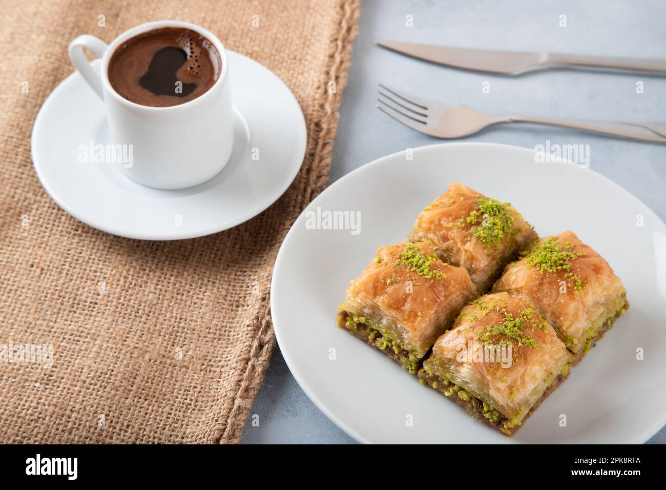 Baklava al pistacchio su un piatto bianco con caffè turco, vista dall'alto Foto Stock