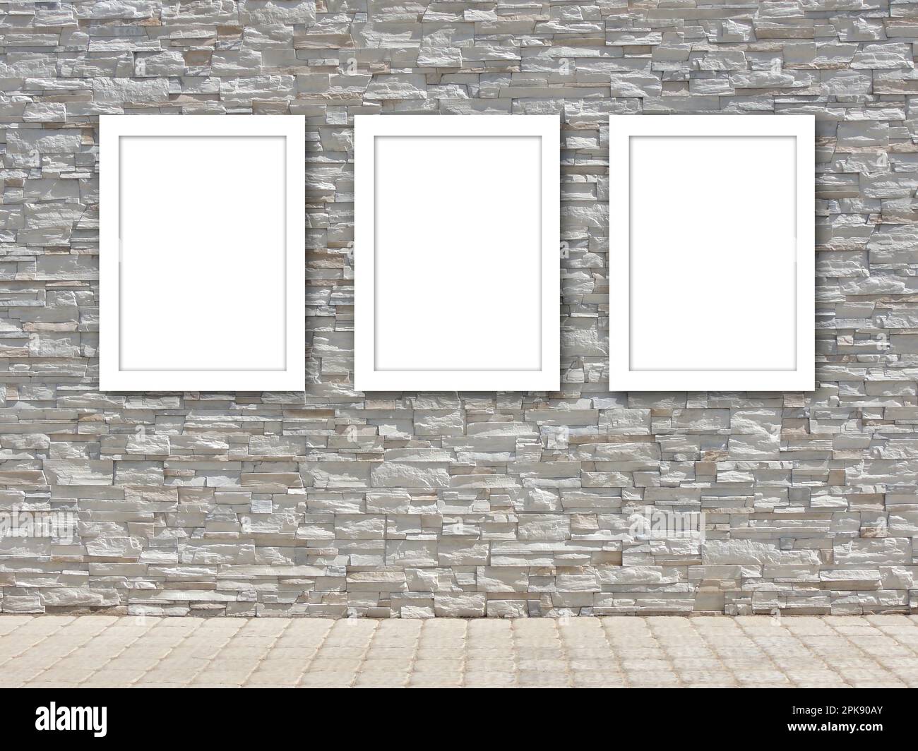 Tre modelli bianchi di cornici vuoti su una parete decorativa in pietra. Foto Stock