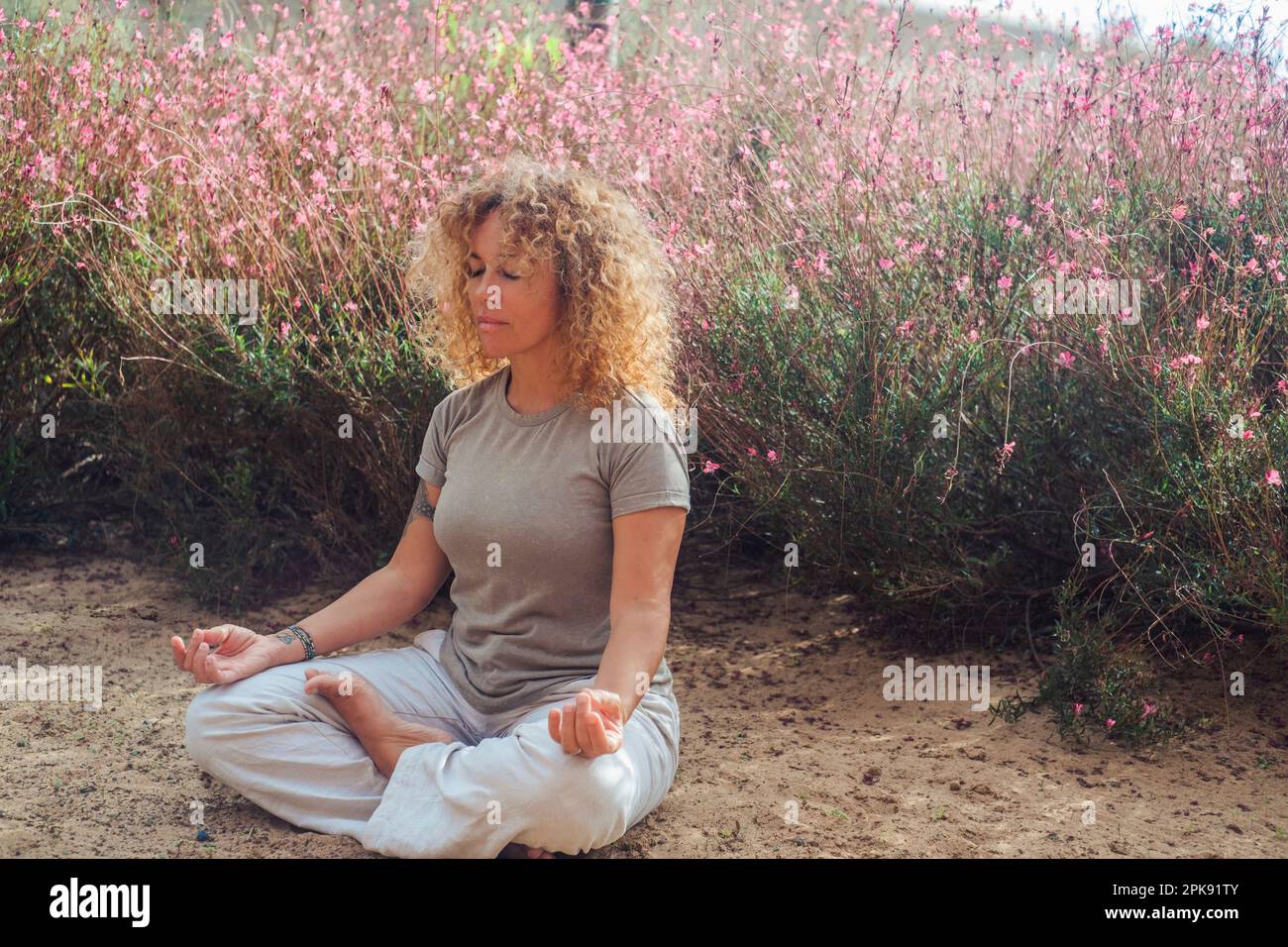 Esercizio di consapevolezza e yoga lotus postura, donna, seduta, fiori, fuori, Foto Stock