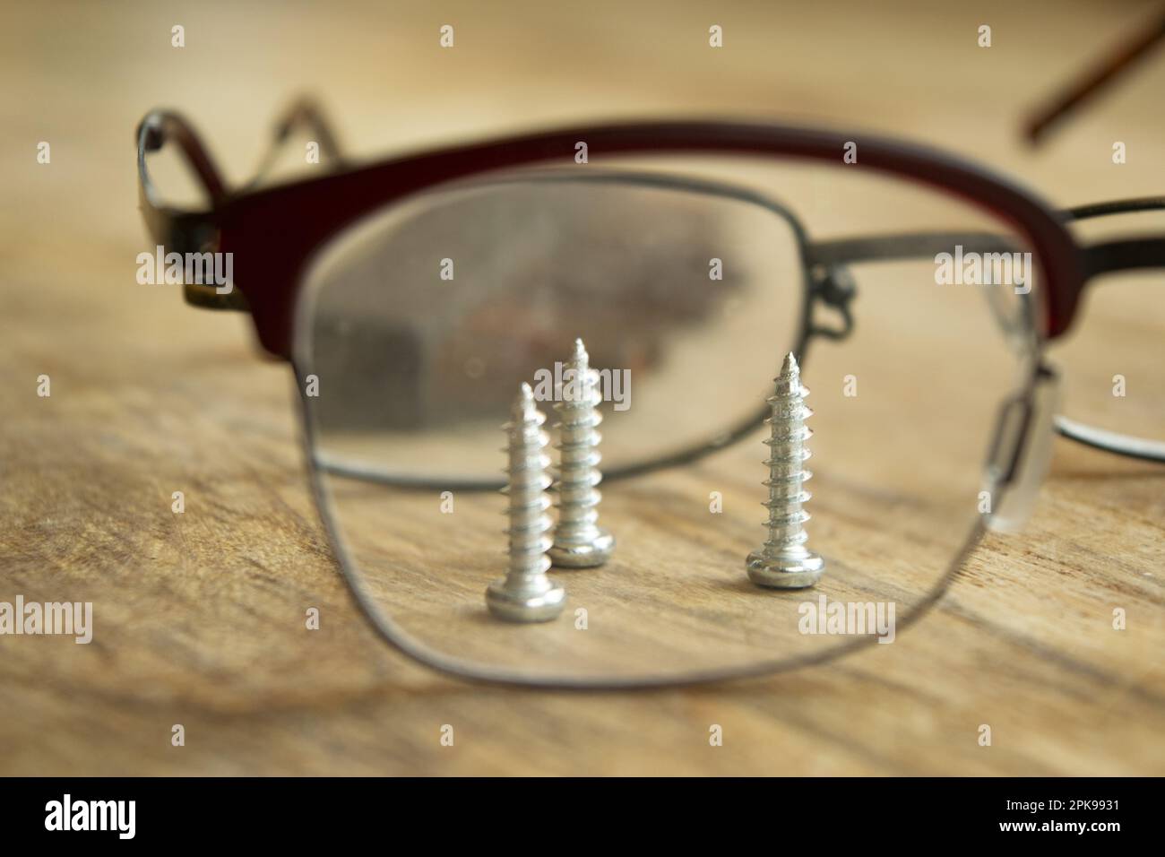 concetto di lavorazione manuale di precisione con viti visibili attraverso gli occhiali Foto Stock