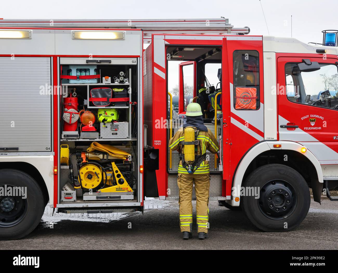 Duisburg, Renania settentrionale-Vestfalia, Germania - esercizio antincendio, le persone vengono salvate da un appartamento in fiamme. Il vigile del fuoco ritorna al camion dei pompieri dopo l'operazione. Evento stampa: Il cancelliere tedesco OLAF Scholz visita l'unità antincendio 530 del dipartimento antincendio volontario di Duisburg presso la stazione antincendio e di soccorso 5 di Homberg. Insieme a un'unità antincendio del reparto antincendio professionale, la scuola antincendio è anche ospitata. Foto Stock