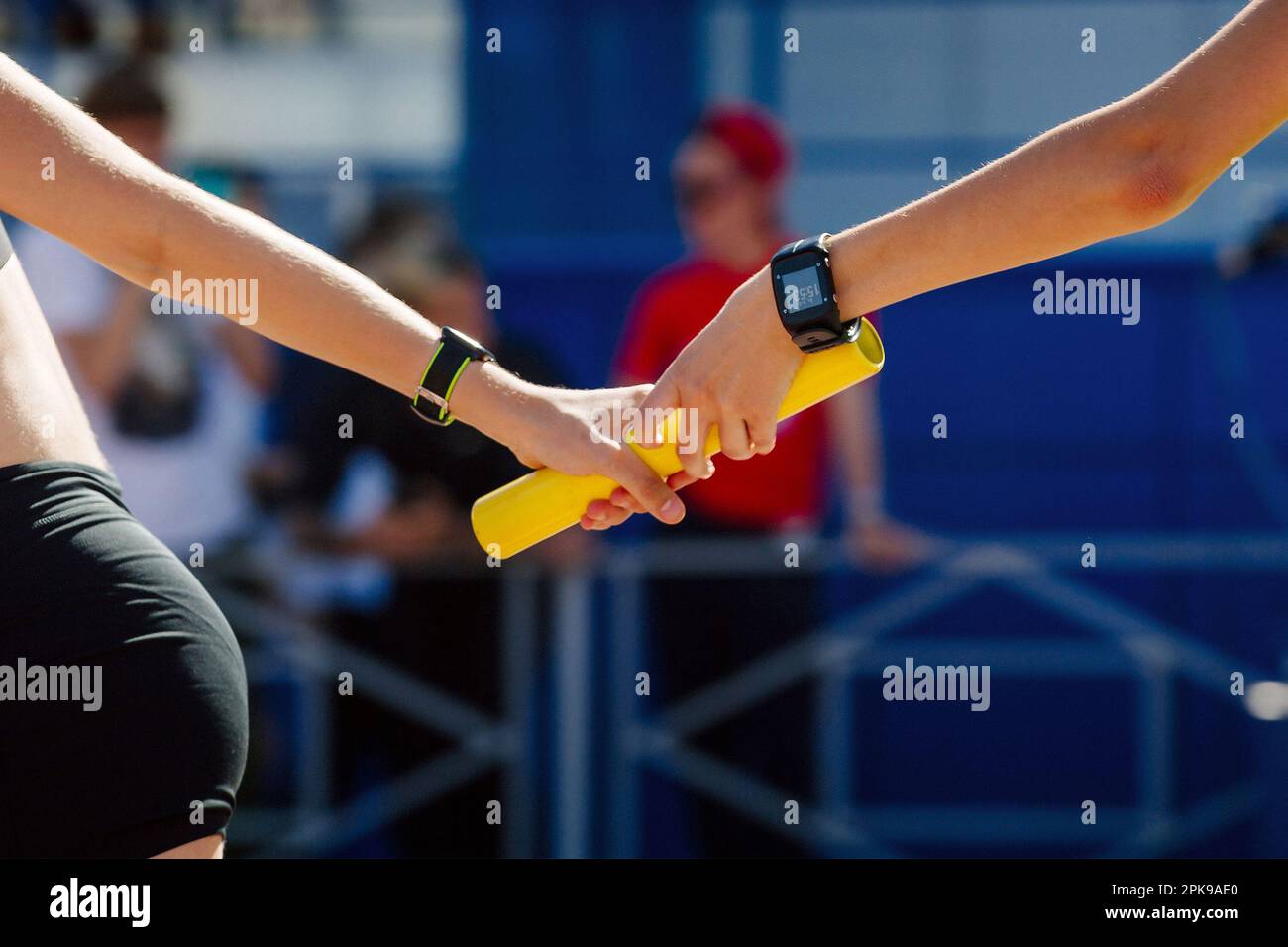 le donne di mano che passano il baton corsa relè nel campionato di atletica estiva Foto Stock