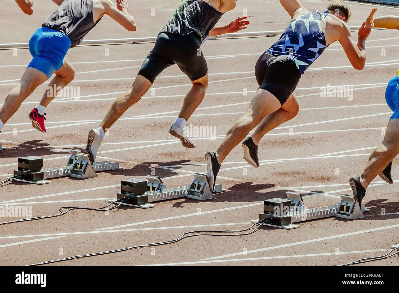 i corridori maschi che iniziano a correre 100 - gara di metri nei campionati estivi di atletica Foto Stock