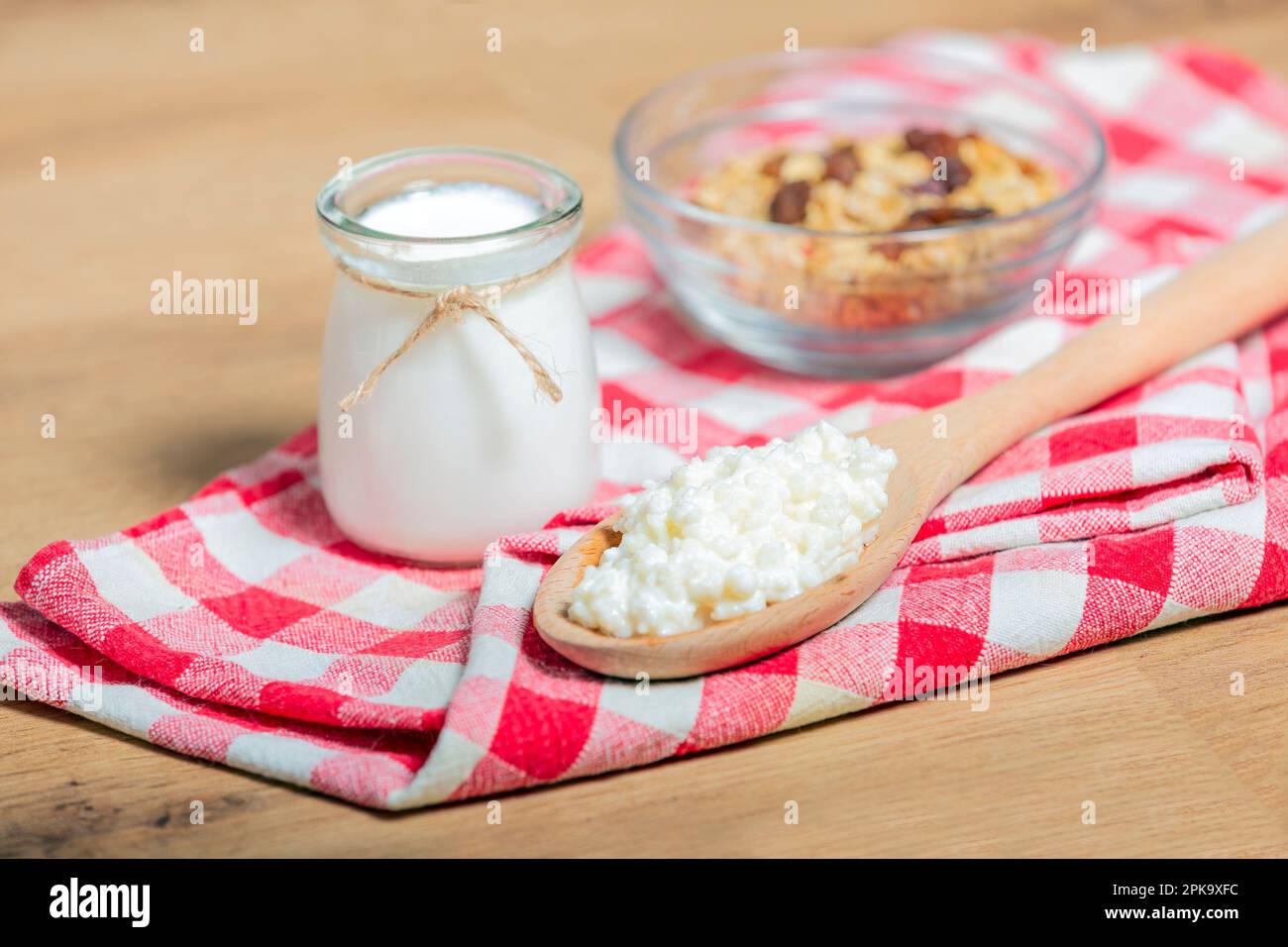 Latte probiotico chicchi di kefir, funghi tibetani su cucchiaio di legno, latte di kefir in contenitori di vetro e cereali sullo sfondo. salute Foto Stock