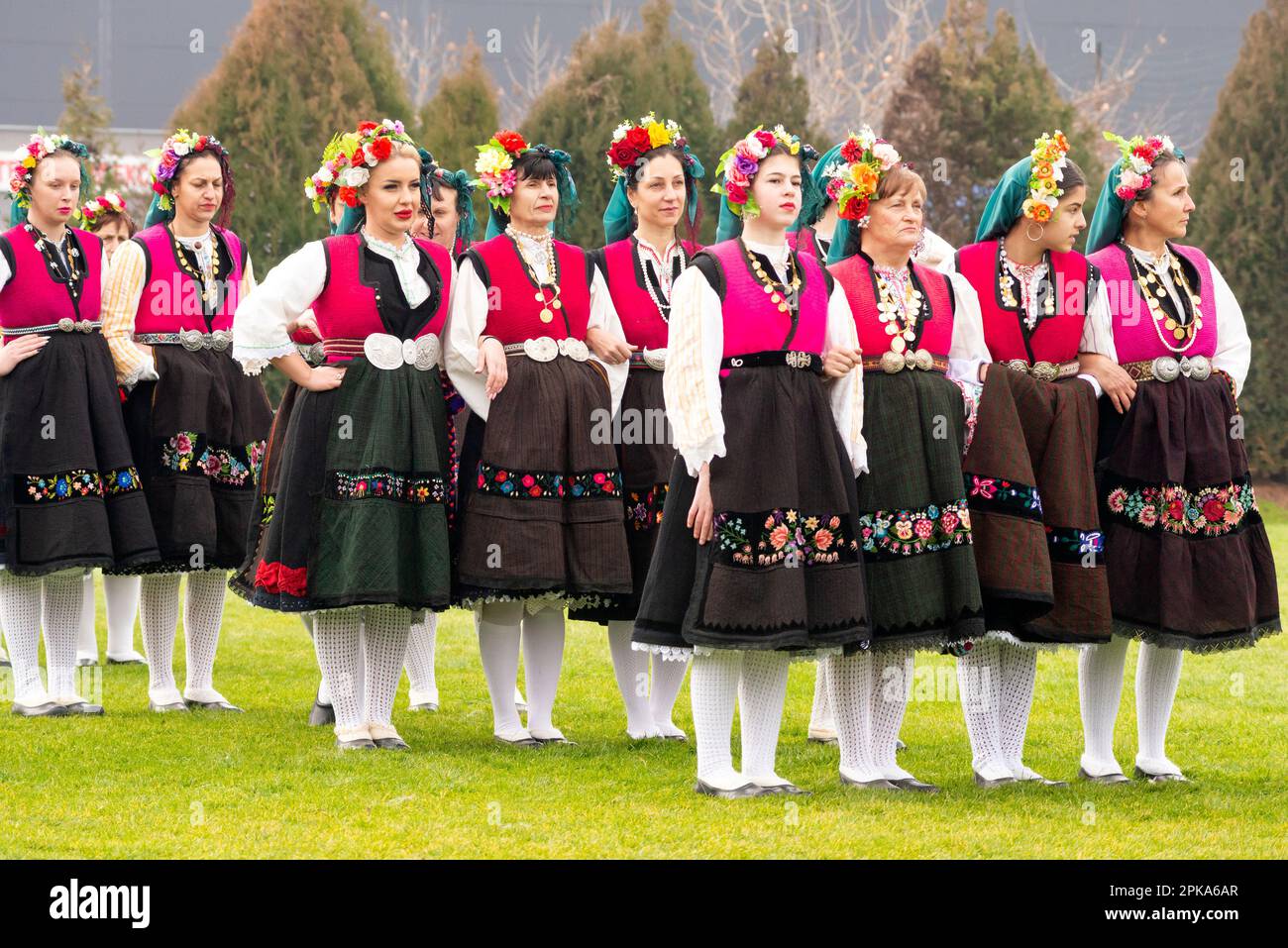 Gruppo di ballerine donne del villaggio di Kliment, regione di Karlovo, vestite con costumi tradizionali folk in attesa di partecipare al festival di Kukeri, Bulgaria Foto Stock