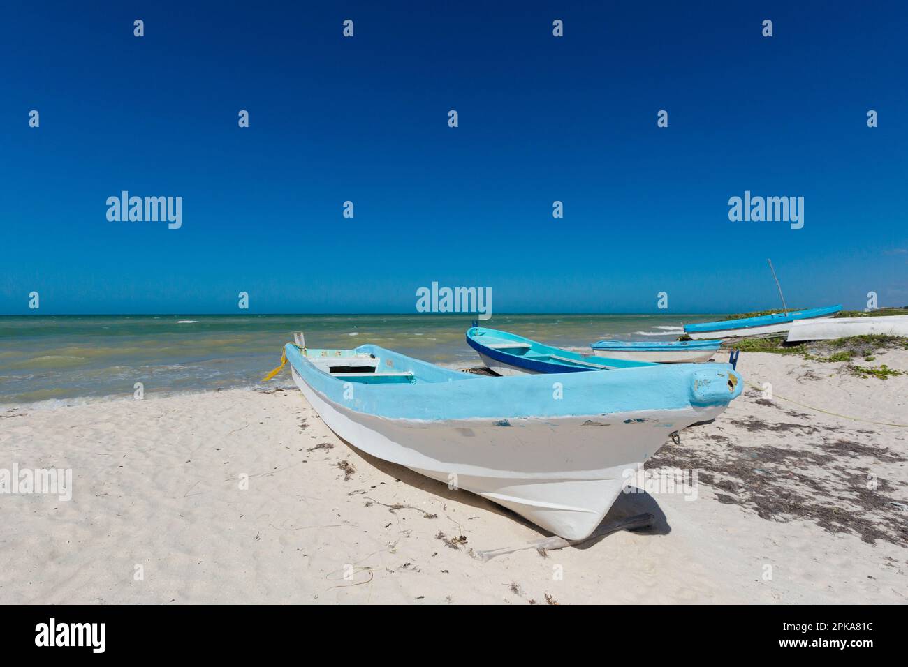 Bella spiaggia di Progreso in Messico durante le giornate di sole con una barca. Spiaggia bianca e cielo blu. Foto Stock