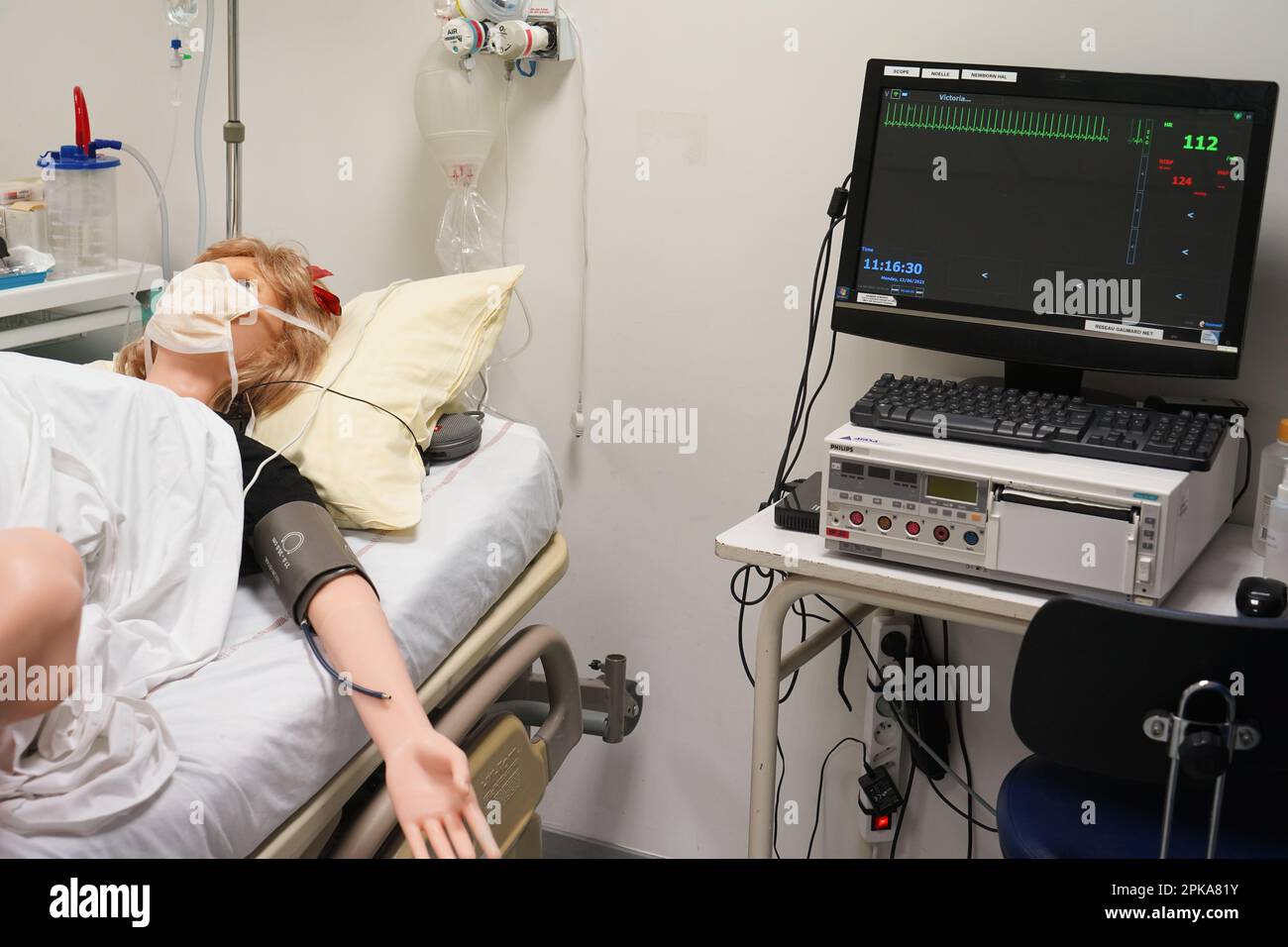 Gli studenti che devono affrontare un'emergenza post-natale seguono le procedure su un manichino. Questo manichino è controllato dagli operatori in una stanza adiacente. Foto Stock