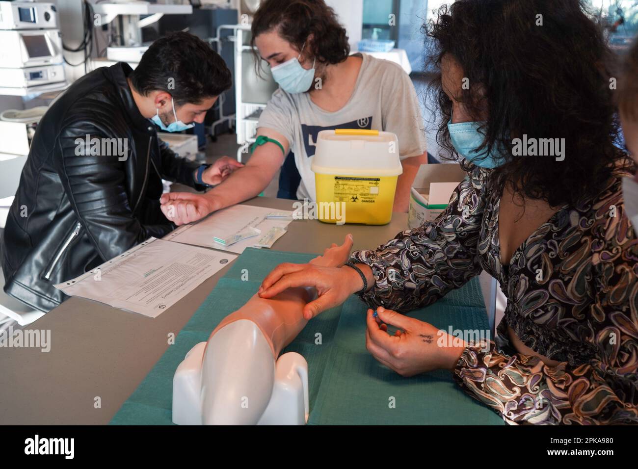5th anni di studenti di medicina durante un workshop di IV tirocinio. Gli studenti si allenano su un braccio arterioso consentendo la puntura arteriosa e venosa per il campionamento del sangue. Foto Stock