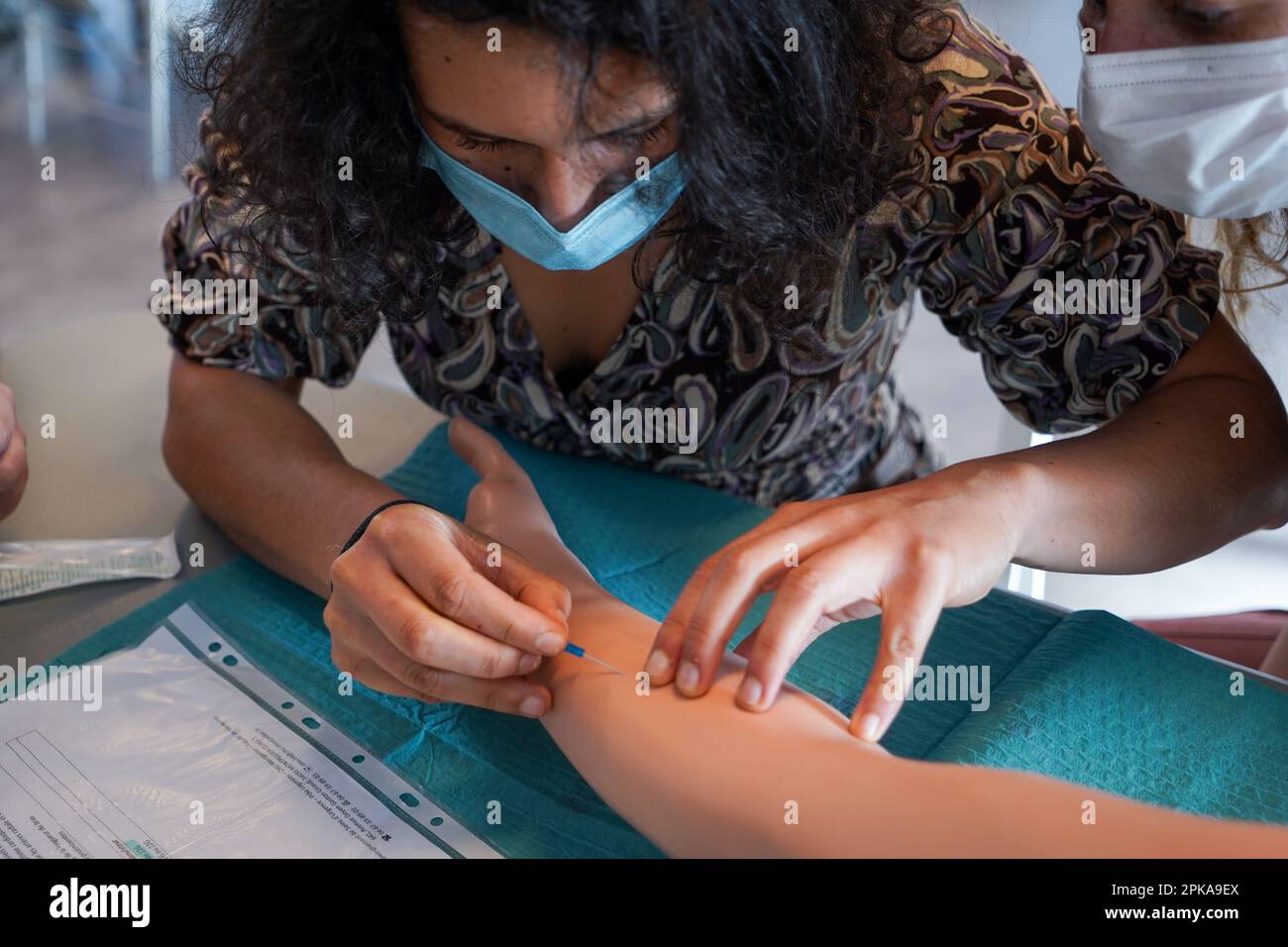 5th anni di studenti di medicina durante un workshop di IV tirocinio. Gli studenti si allenano su un braccio arterioso consentendo la puntura arteriosa e venosa per il campionamento del sangue. Foto Stock
