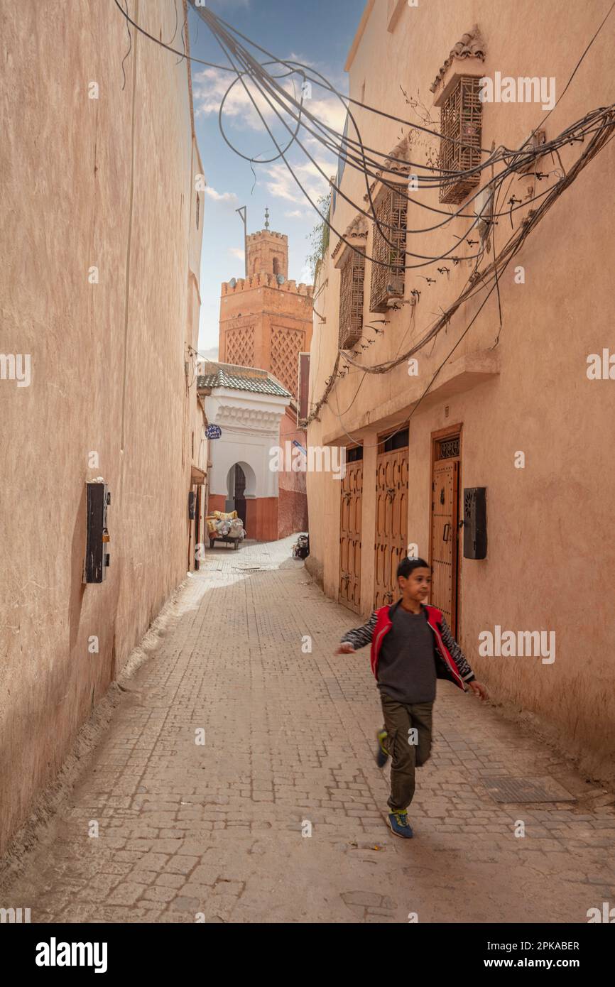 Marocco, Marrakech, medina, città vecchia, strade strette, street scene, running boy Foto Stock