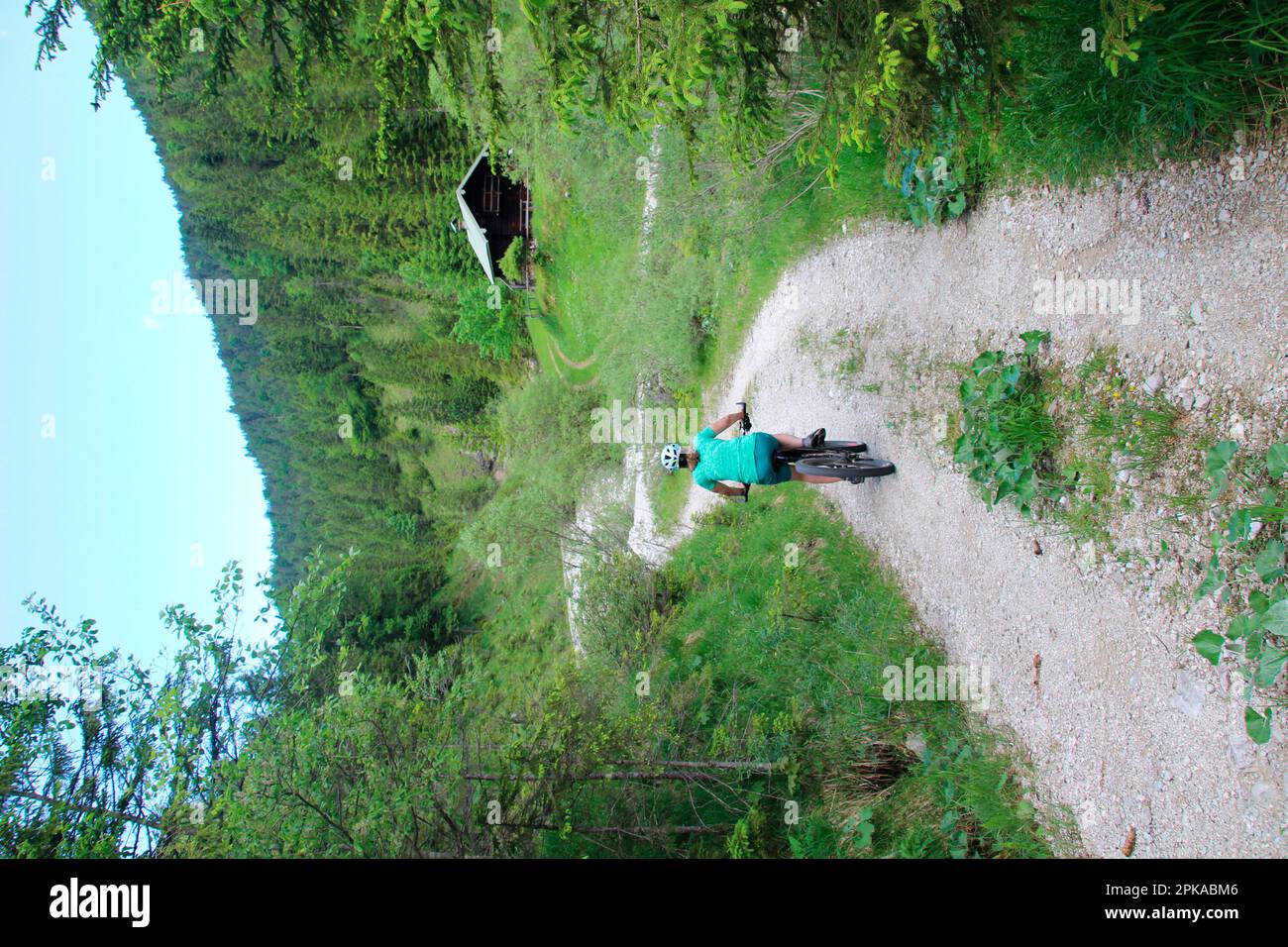 Donna su e-bike, ciclista, rifugio di caccia a Fischbachtal, sentiero escursionistico, estate, Alpenwelt Karwendel, Krün, Germania, Baviera, alta Baviera Foto Stock