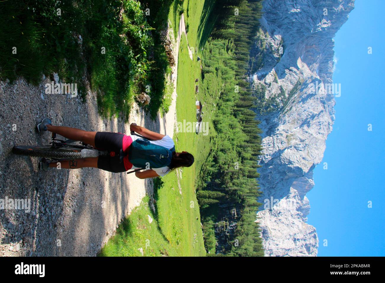 Giovane donna con mountain bike poco prima di Wettersteinalm 1464m, clima estivo, Germania, Baviera, Werdenfels, Montagne di Wetterstein, Wetterstein, Gar Foto Stock