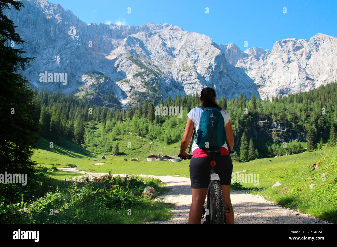 Giovane donna con mountain bike poco prima di Wettersteinalm 1464m, clima estivo, Germania, Baviera, Werdenfels, Montagne di Wetterstein, Wetterstein, Gar Foto Stock