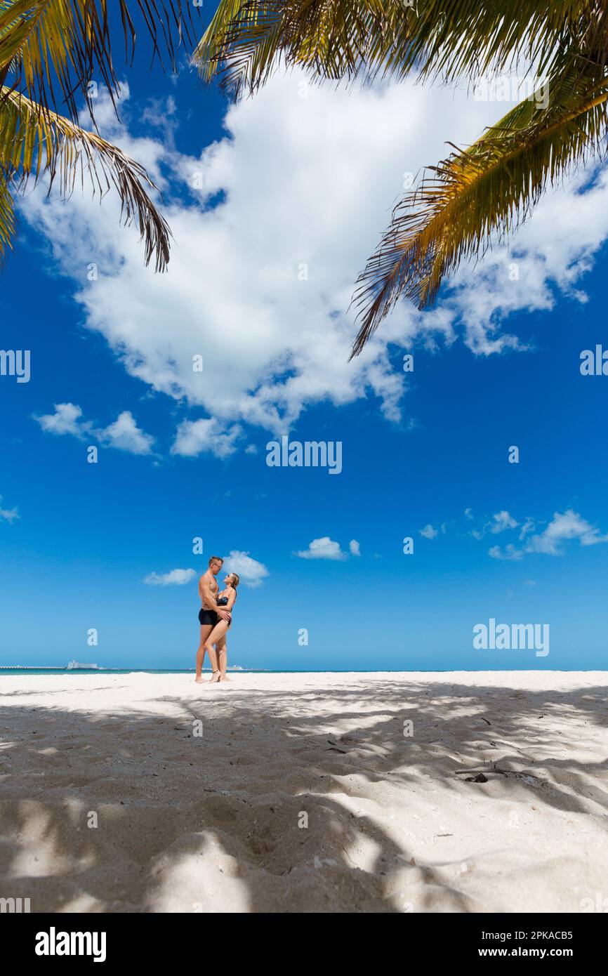 Bella giovane coppia felice a Progreso Beach, Messico durante le giornate di sole. Spiaggia bianca e cielo blu. Foto Stock