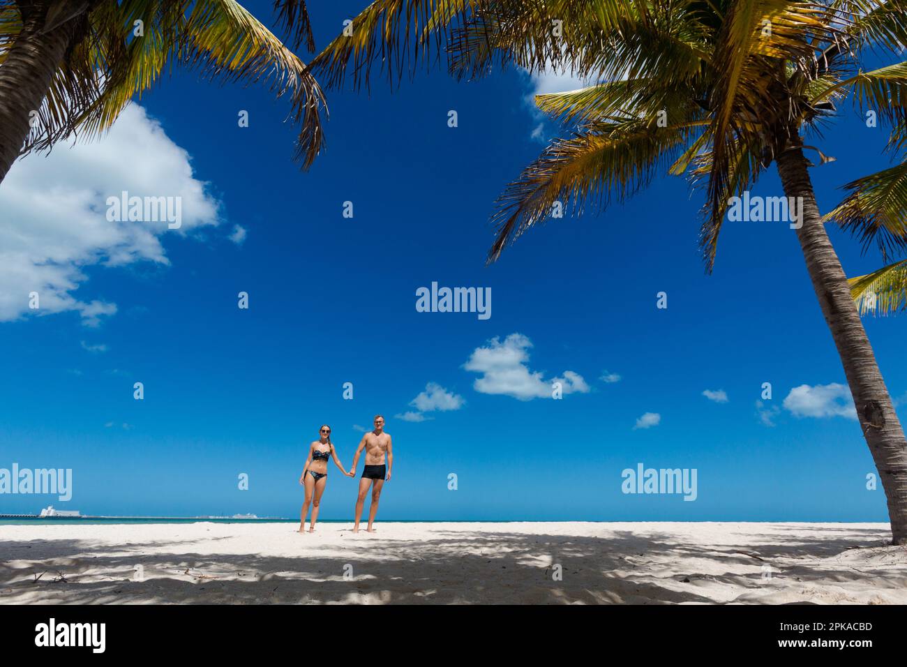Bella giovane coppia felice a Progreso Beach, Messico durante le giornate di sole. Spiaggia bianca e cielo blu. Foto Stock