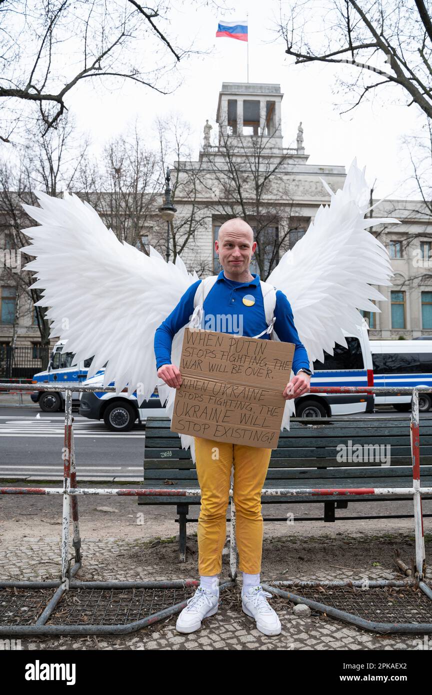 24.02.2023, Germania, , Berlino - Europa - Angelo della pace Jonas Schmidt dimostra contro la guerra in corso con le ali degli angeli e un segno di protesta sul Foto Stock