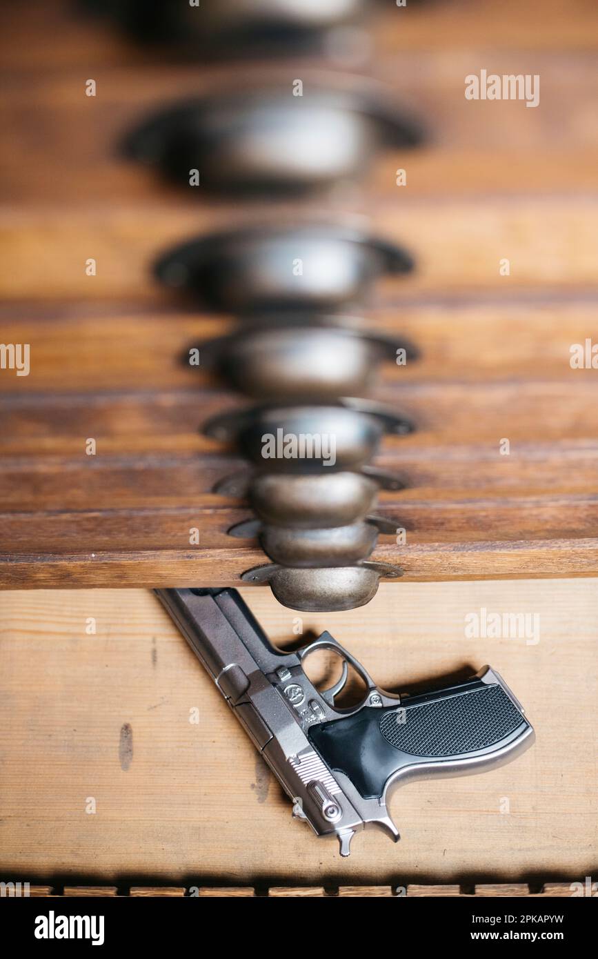 Pistola nel cassetto inferiore di una vecchia cassettiera Foto Stock