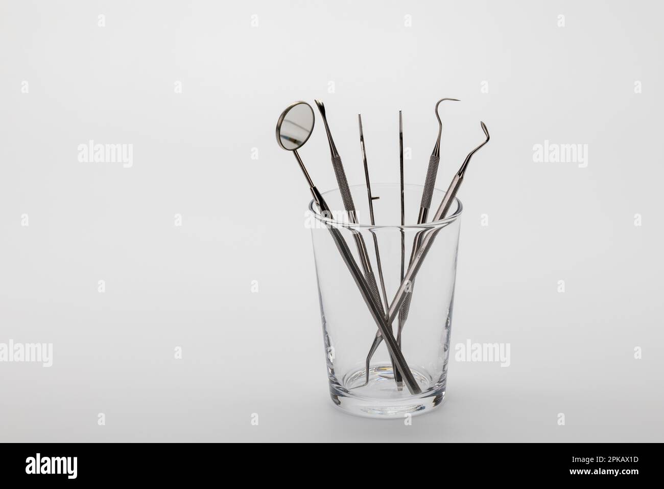 Set per la cura dei denti in vetro todontoiatrico, fondo bianco, Foto Stock